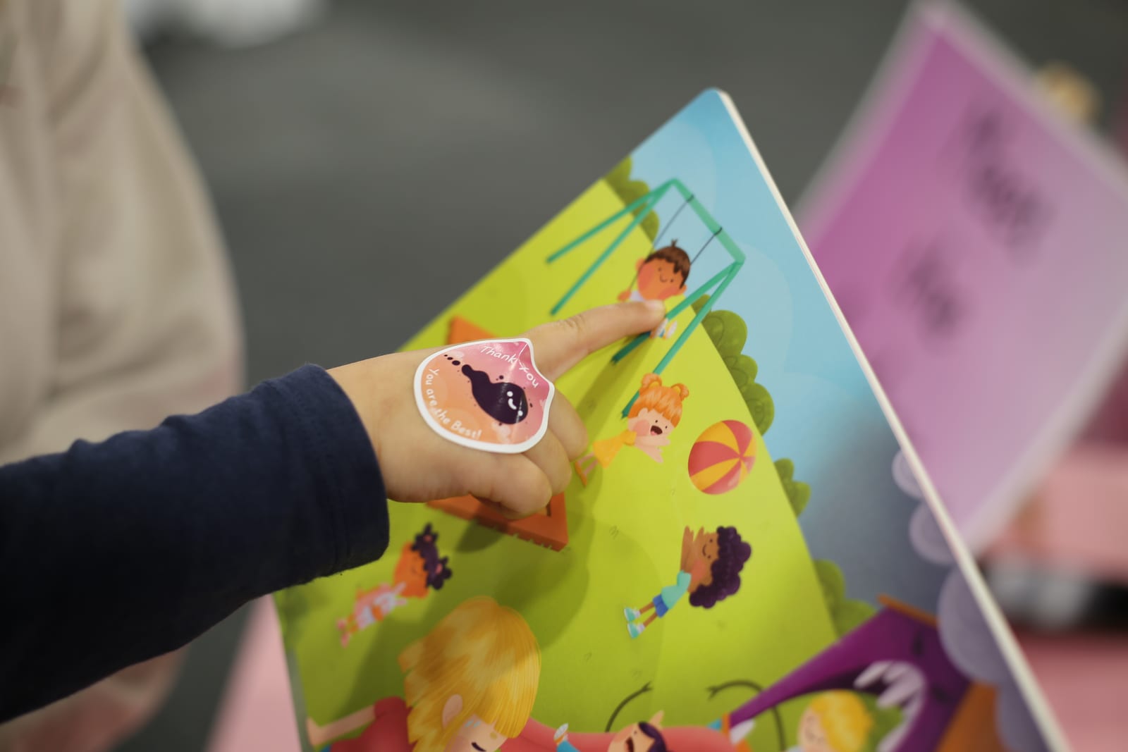A child's hands turning the pages of the book