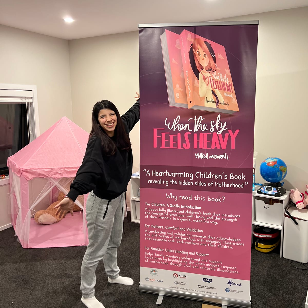 Luciana at a book event beside a promotional banner